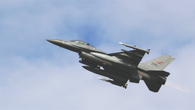 A dynamic shot of an F-16 military jet soaring through a clear sky, showcasing advanced aviation technology.